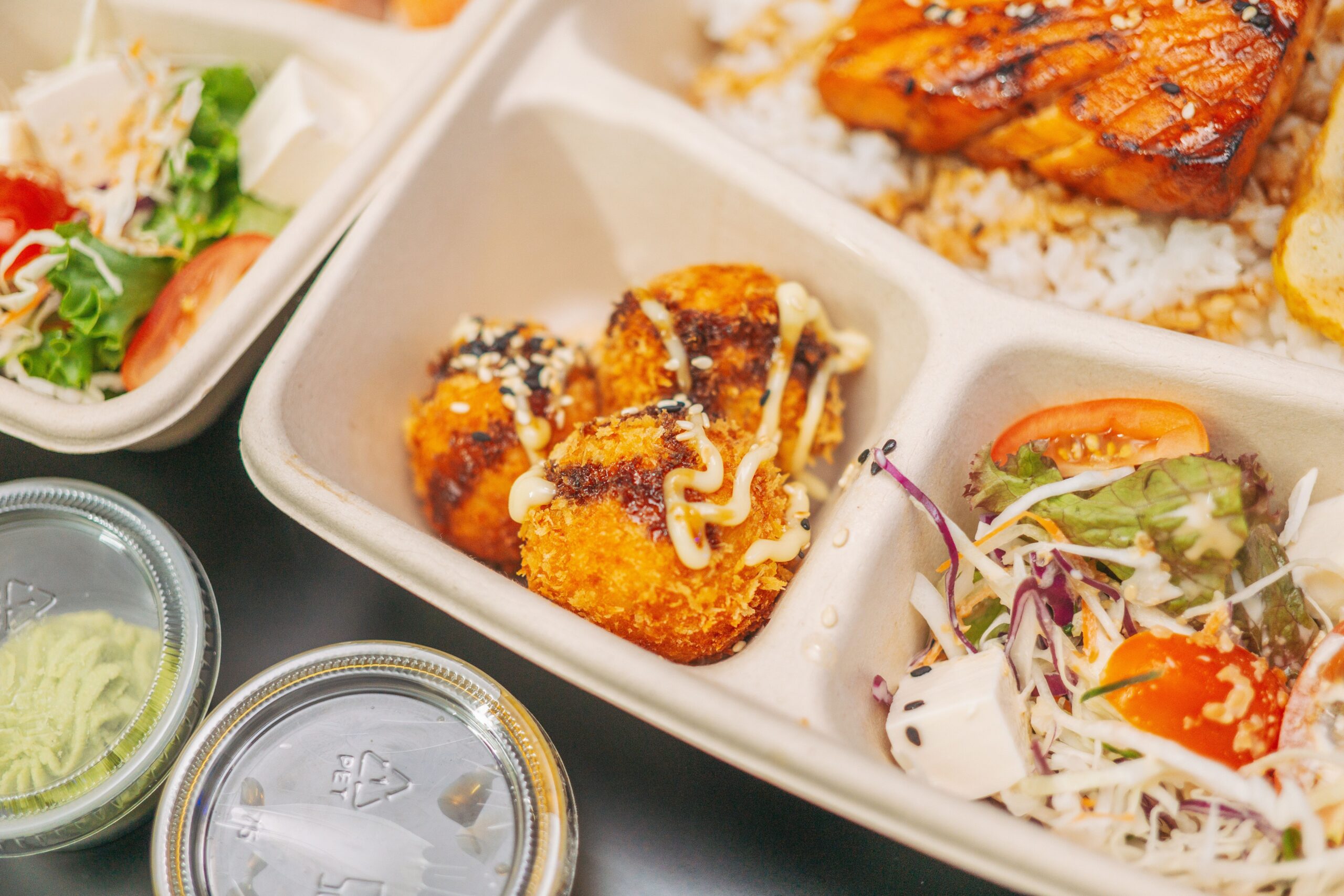 pexels photo 13189288 13189288 Close-up of a bento box with grilled salmon, rice, salad, and croquettes.